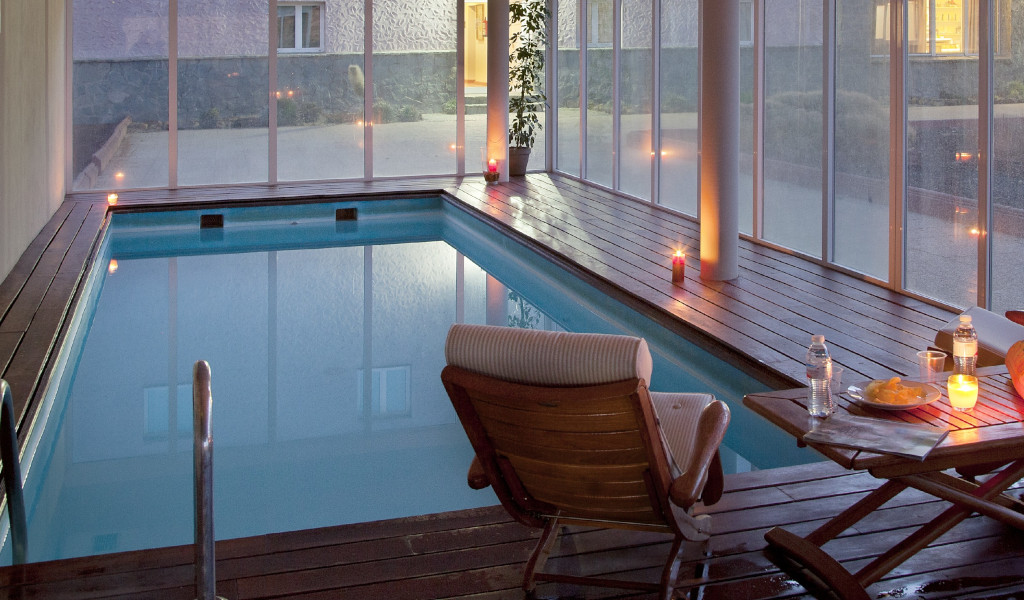 Indoor swimming pool with chairs, table and candles in a hotel in Tenerife.