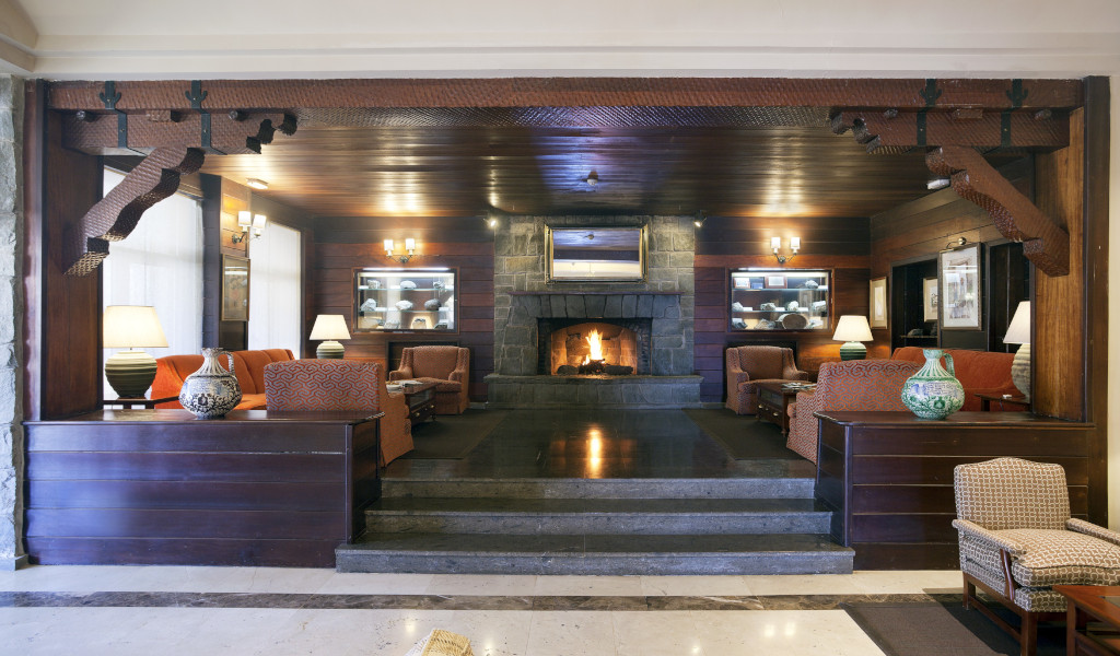 Living room with fireplace, sofas and lamps in hotel in Tenerife.