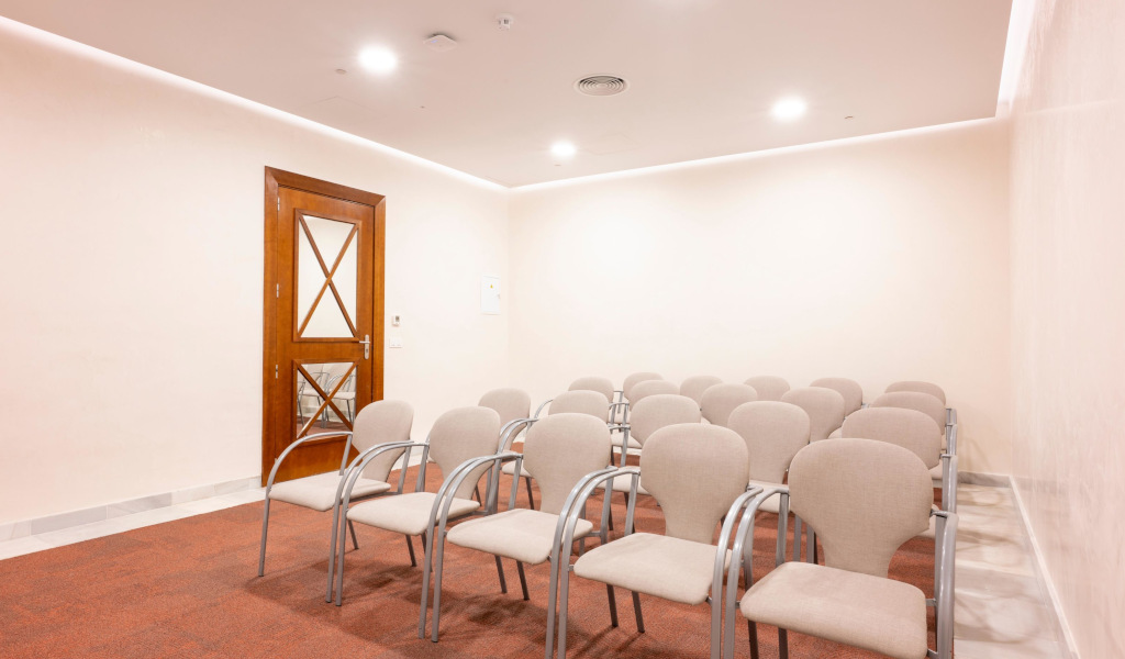 Empty conference room with chairs and wooden door in Tenerife.