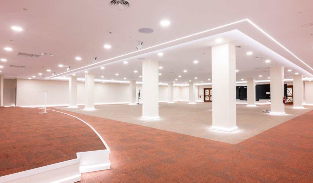 Spacious room with white columns and illuminated ceiling in a modern space in Tenerife.