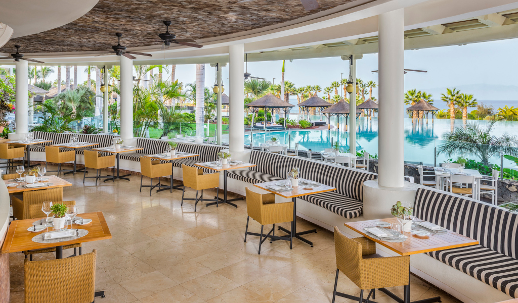 Restaurant with tables and chairs by the pool in Tenerife.