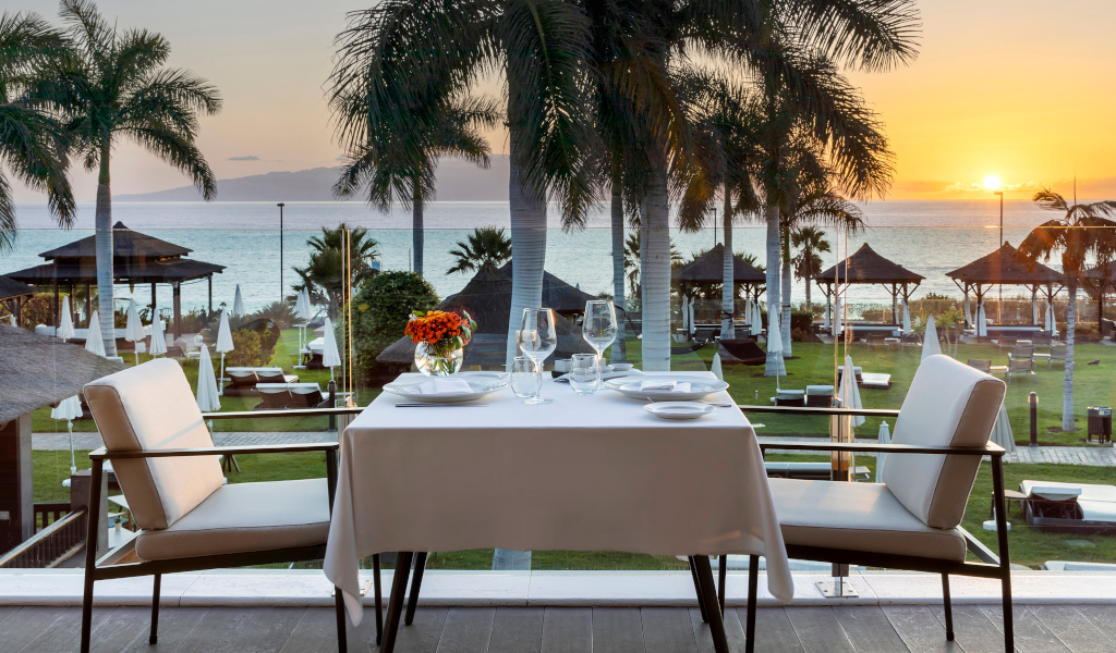 Table on terrace with sea view at sunset in Tenerife.