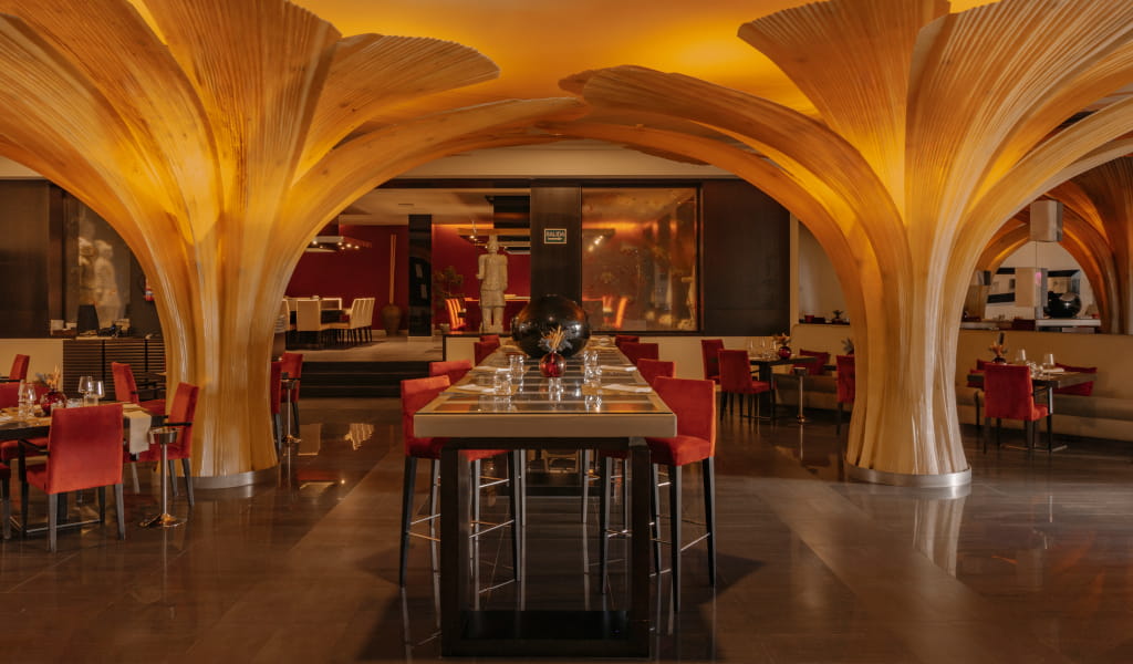 Restaurant with wooden column decoration and red chairs in Tenerife.