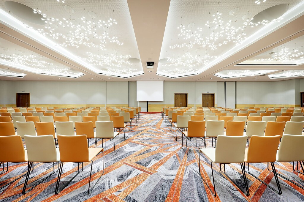 Empty conference room in Tenerife with chairs lined up and ceiling lit.