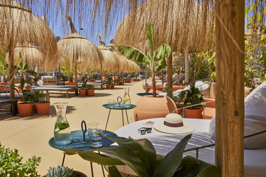 Terrace with straw umbrellas and plants in a courtyard in Tenerife.