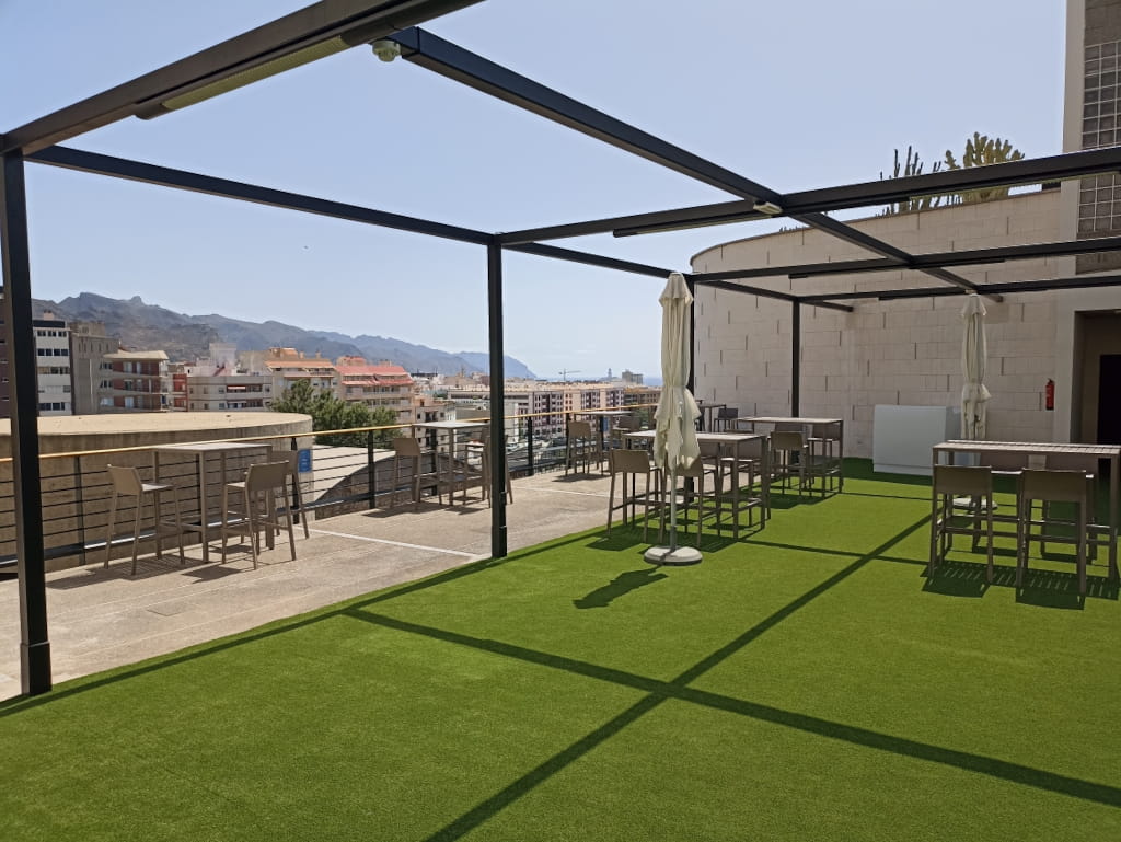 Terrace with tables and chairs, view of Santa Cruz de Tenerife in the background.