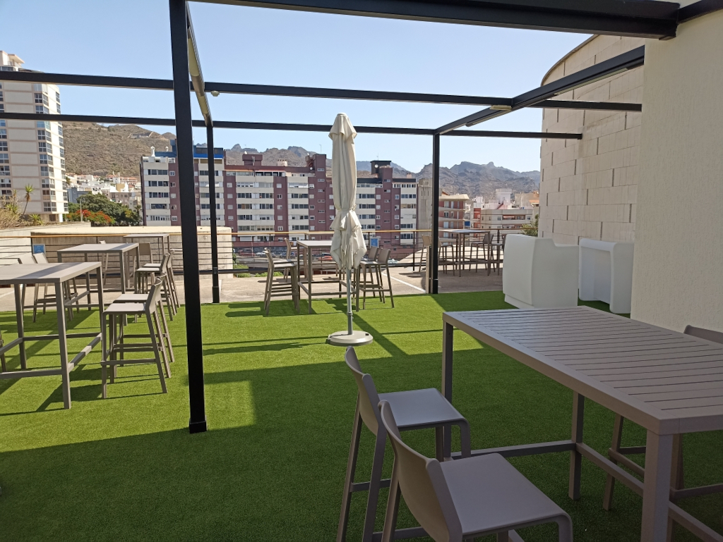 Terrace with tables and chairs overlooking buildings in Santa Cruz de Tenerife.