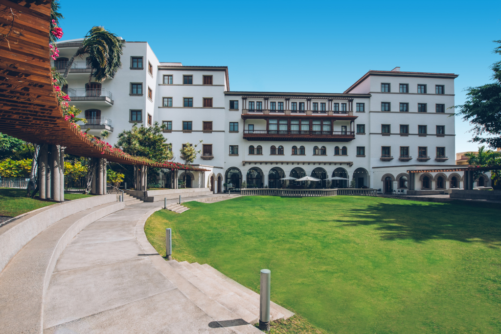 White building with green garden and pergola in Santa Cruz de Tenerife.