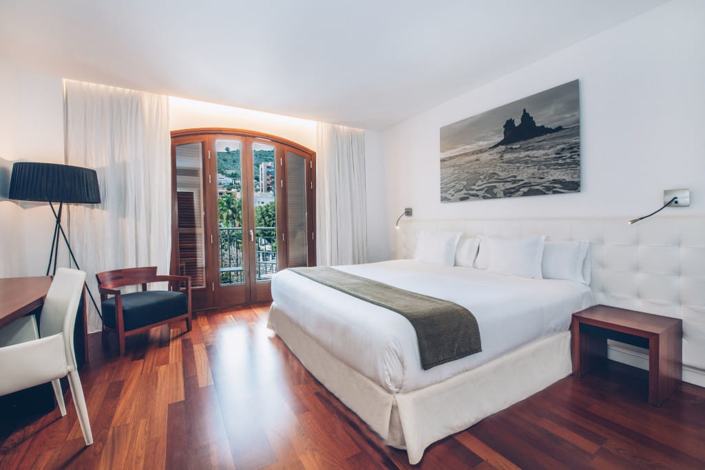 Modern room with double bed, desk and window with views in Tenerife.
