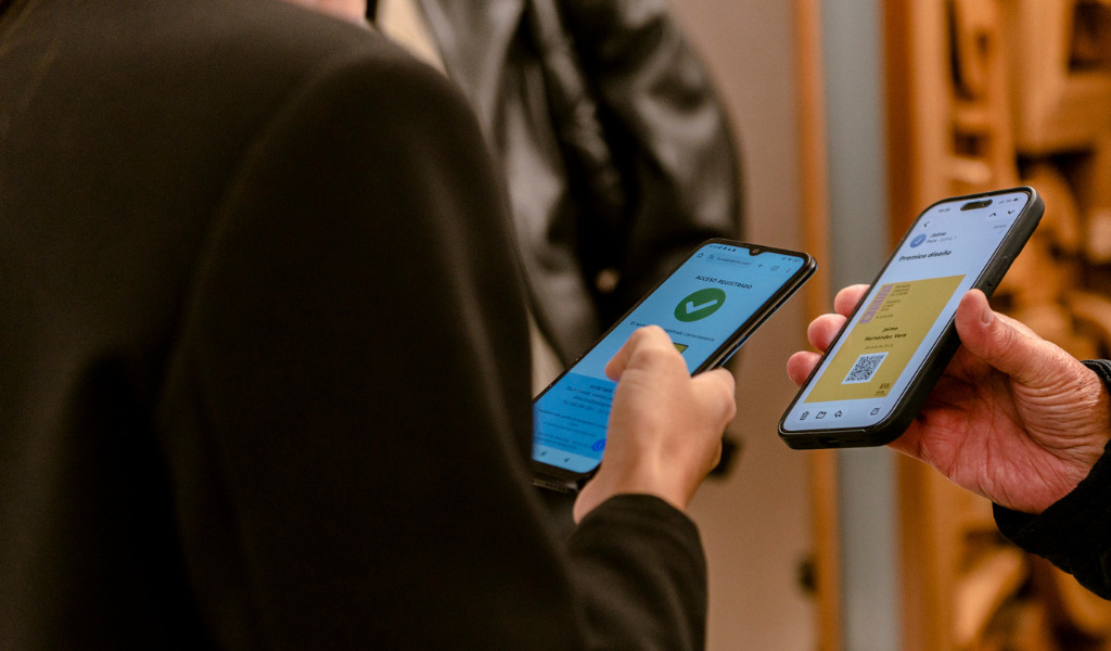 Two people checking QR codes on mobile phone screens.