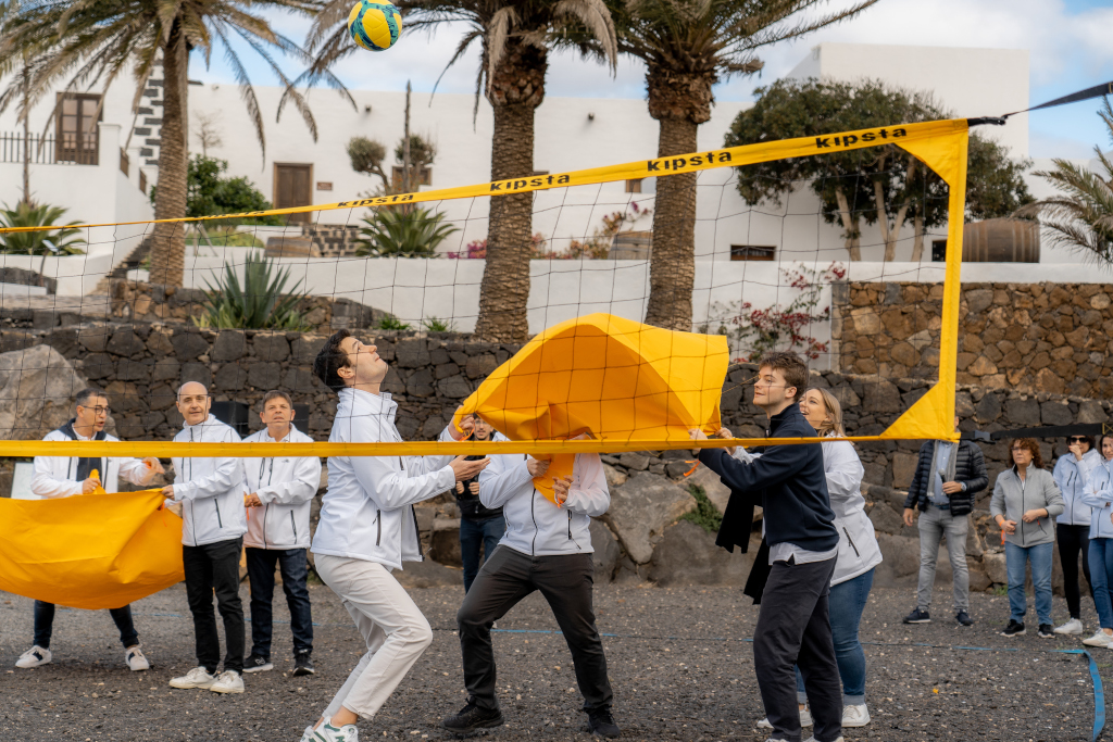 People playing volleyball with a yellow cloth in a courtyard in Tenerife.