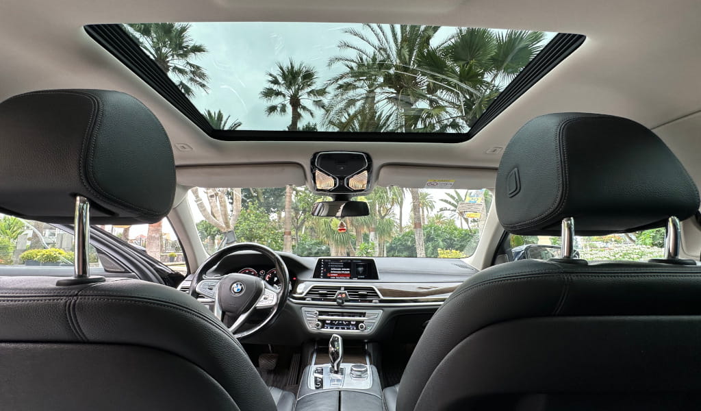 Interior of a car with a view of the sky and palm trees in Tenerife.