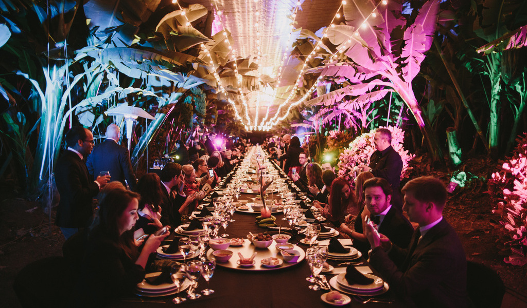 Outdoor dining with lights and people sitting at a long table in Tenerife.