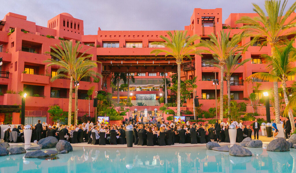 Outdoor event with people in Santa Cruz de Tenerife in front of a terracotta-colored building.