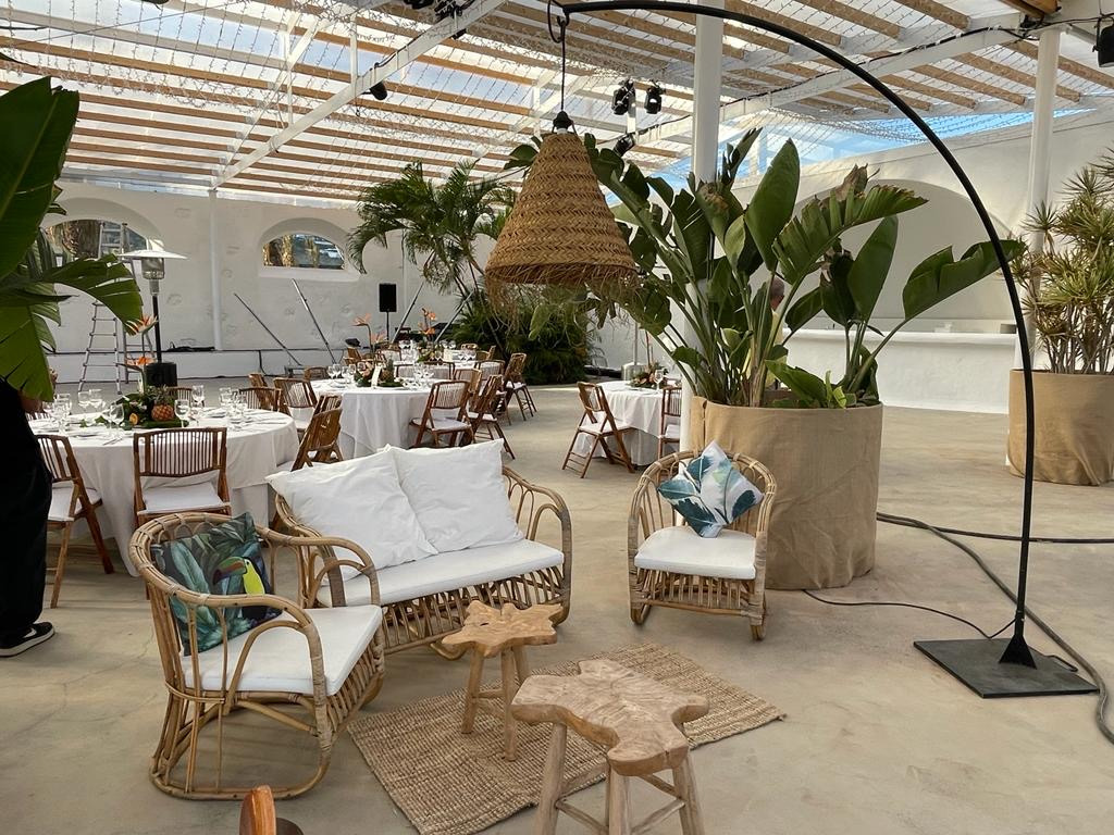 Space decorated with wicker tables and sofas at an event in Tenerife.