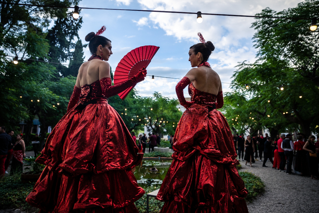 Two people in red dresses and a fan at an outdoor event in Tenerife.
