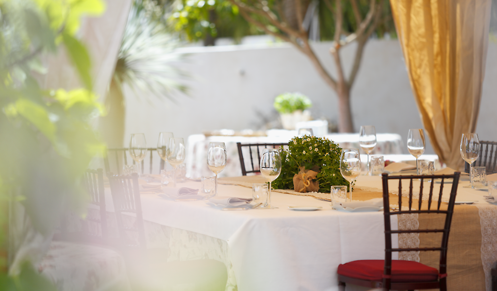 Table prepared with glasses and flower centerpiece in outdoor restaurant in Tenerife.