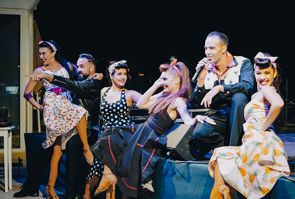 Entertainers in vintage outfits perform on stage at a Tenerife event.