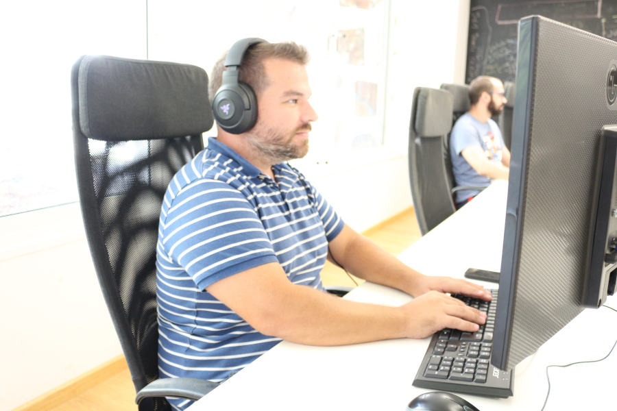 Person with headphones typing on a computer in an office in Tenerife.