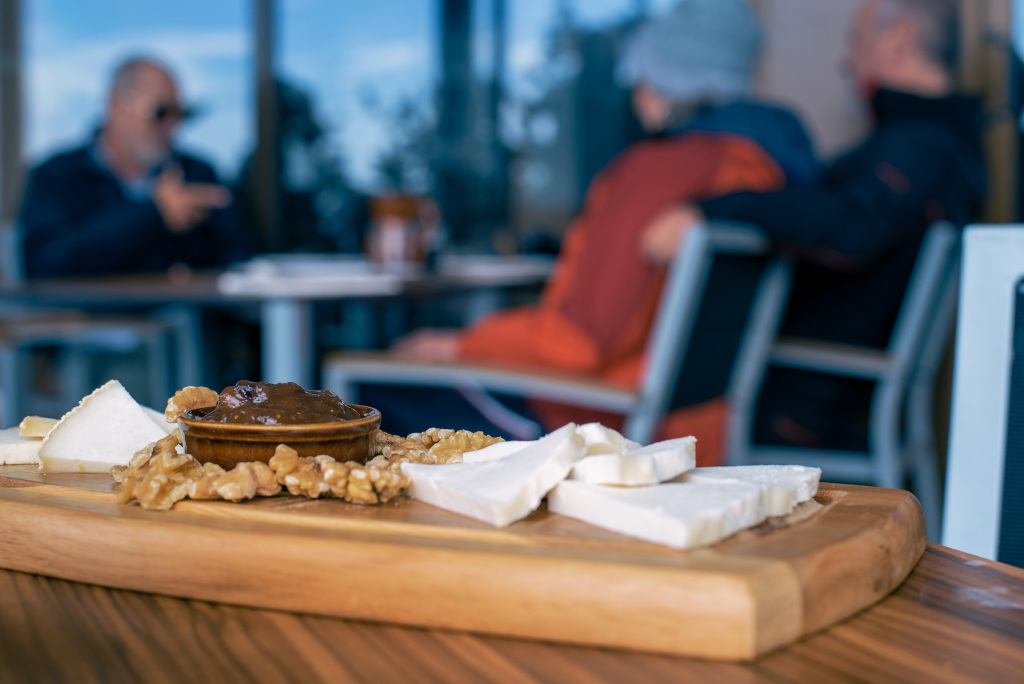 Cheese and walnut platter with three people at a Mount Teide cafe table in Tenerife.
