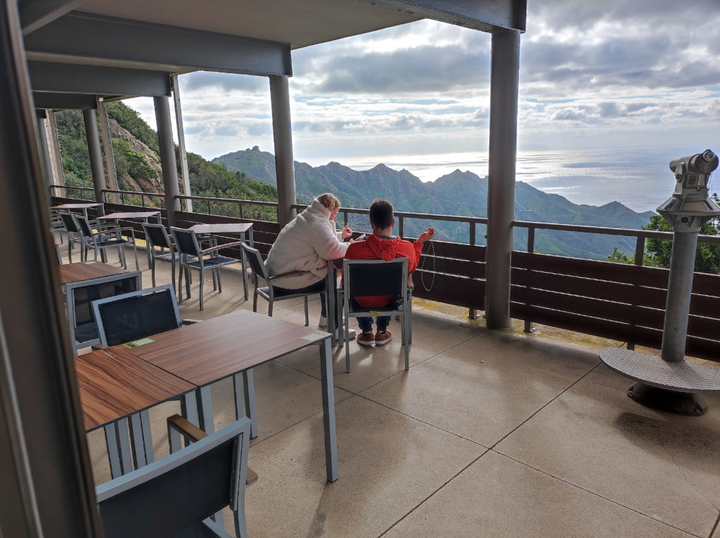 Two people sitting on a terrace overlooking the mountains in Tenerife.