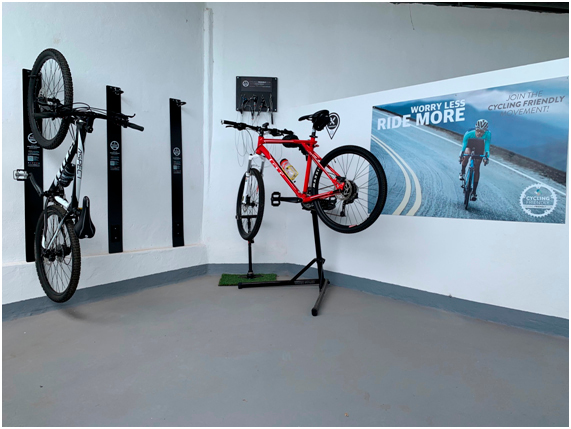 Two bicycles mounted on a wall in a Tenerife cycling center with a cycling poster.