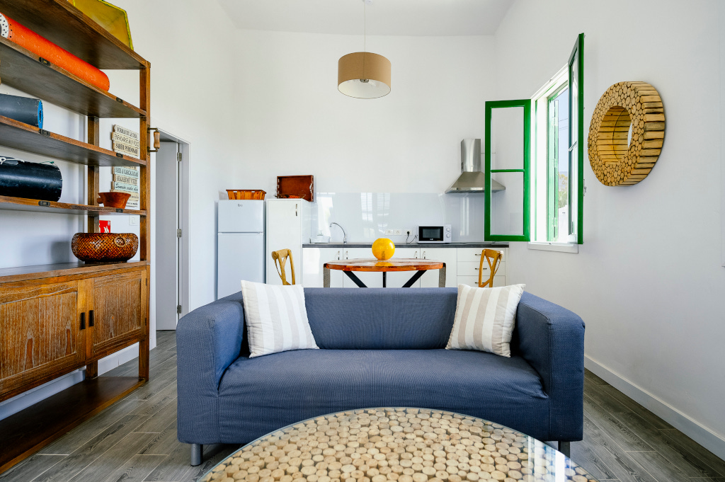 Living room with blue sofa, kitchen with fridge and microwave, in Tenerife.