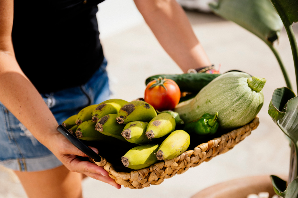 Basket of bananas, zucchini, tomato, cucumber, and bell pepper in Tenerife.