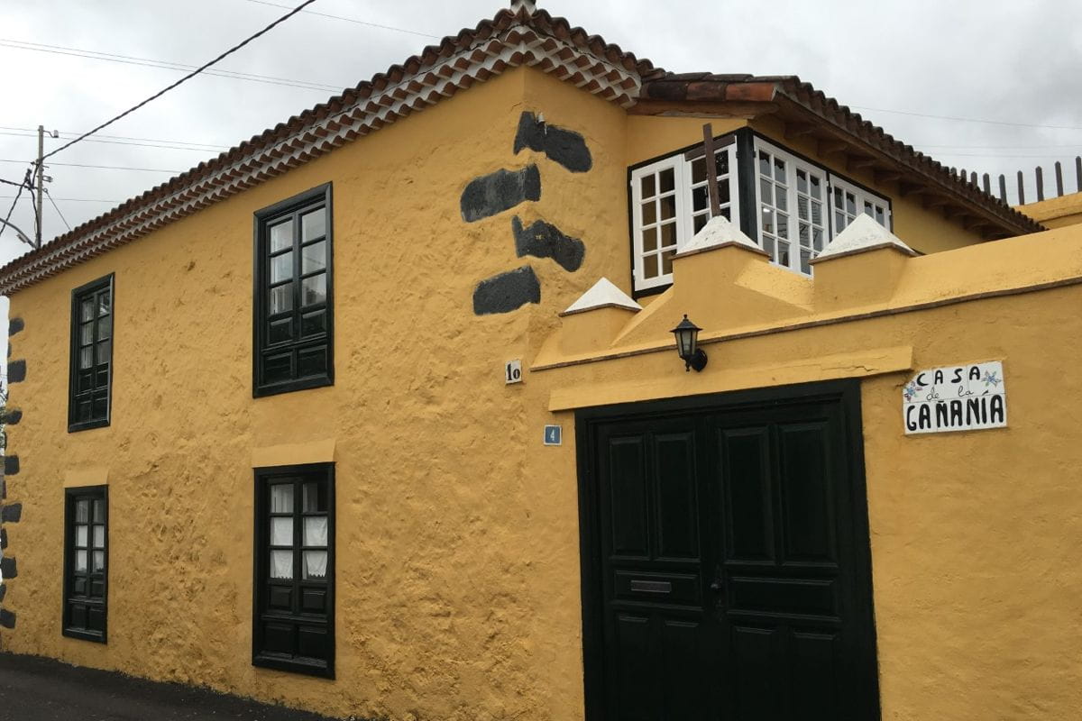 Yellow building labeled Casa de la Gañanía in Tenerife with dark green windows.