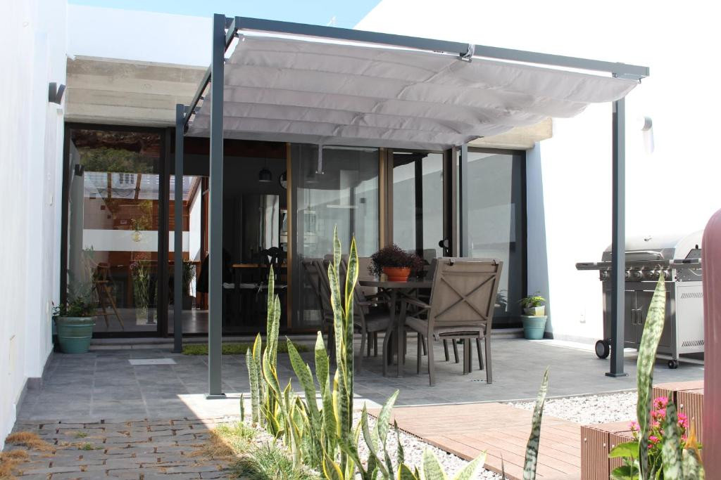 Outdoor dining area with pergola and barbecue in Tenerife patio.