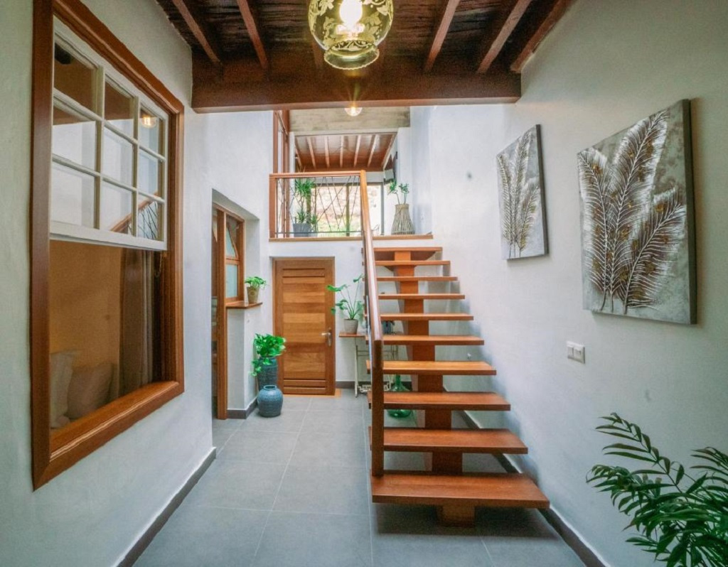 Wooden staircase in a Tenerife house interior with plants and wall art.