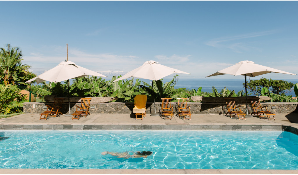 Poolside with umbrellas and lounge chairs, ocean view in Tenerife.