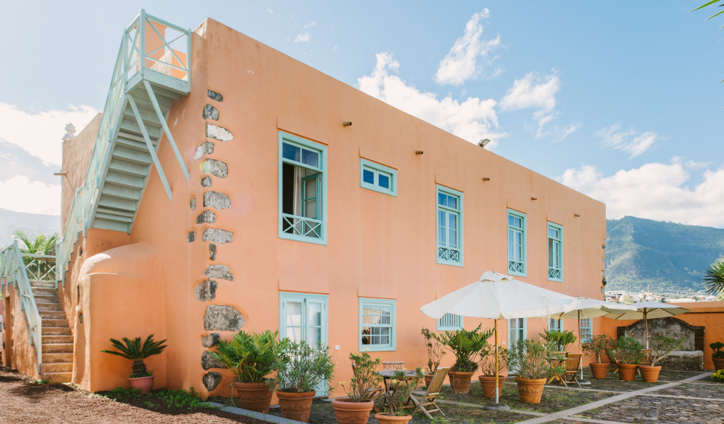Orange house with blue windows and outdoor seating in La Orotava, Tenerife.