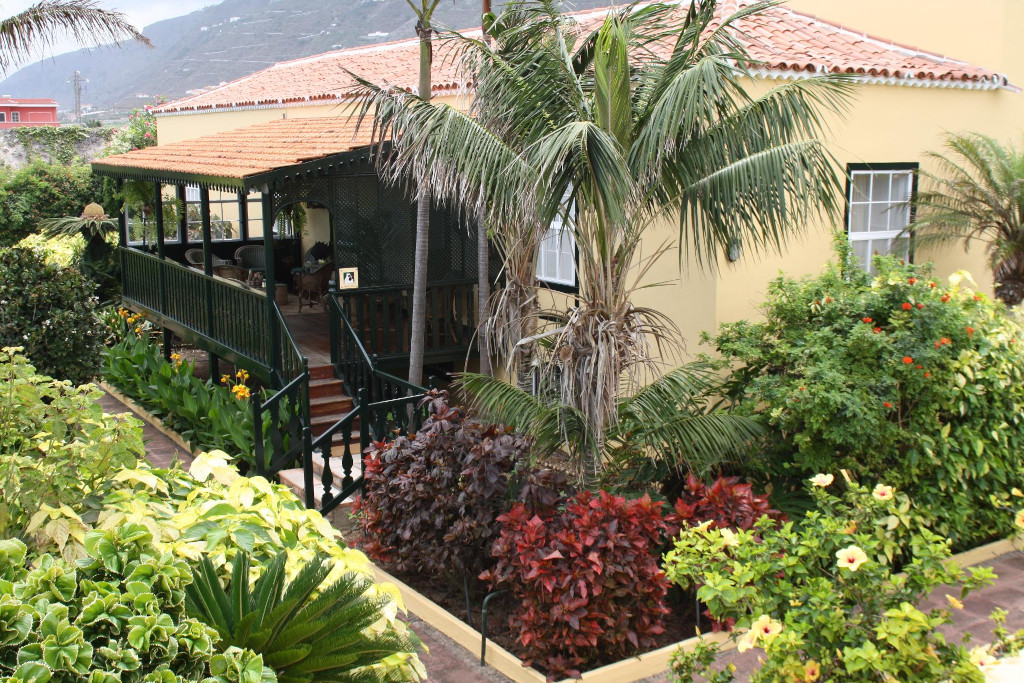 Yellow house with veranda and tropical garden in Tenerife.