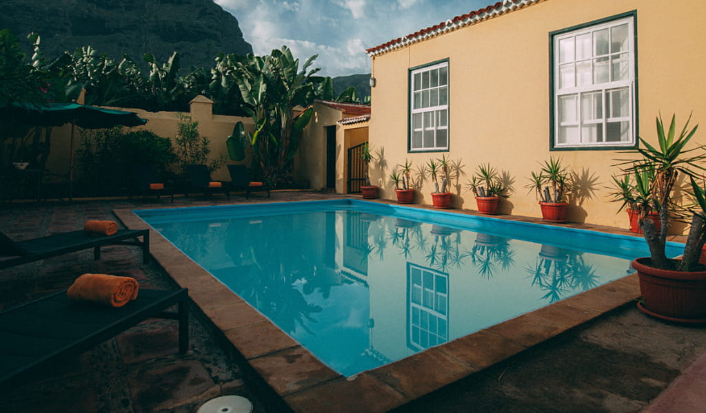 Swimming pool in a courtyard surrounded by potted plants in Tenerife.