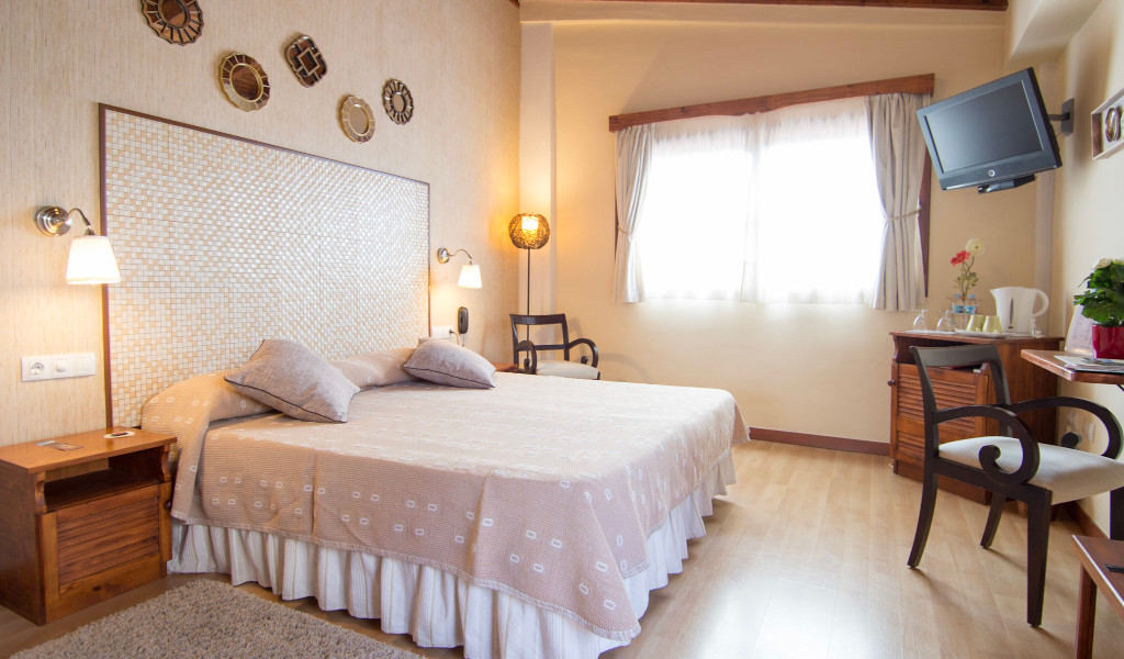 Cozy hotel room in Tenerife with a bed, chairs, and a window.