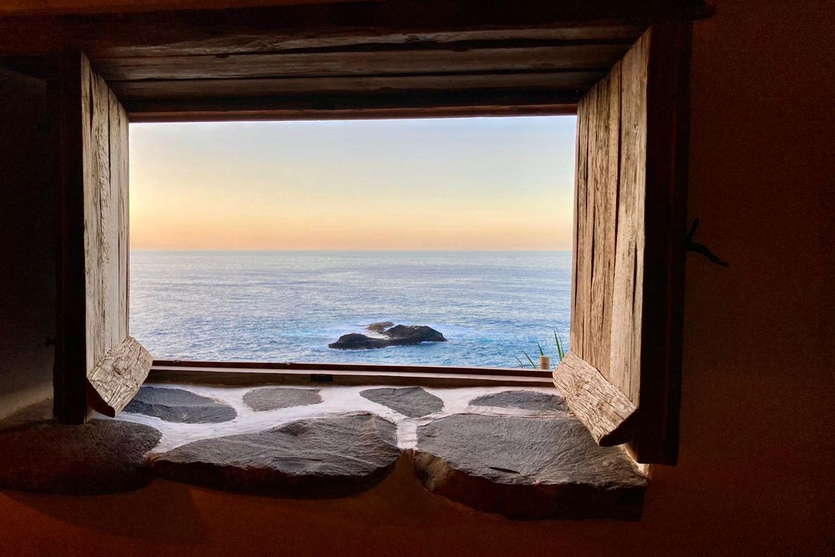 Open wooden window with ocean view at sunset in Tenerife.