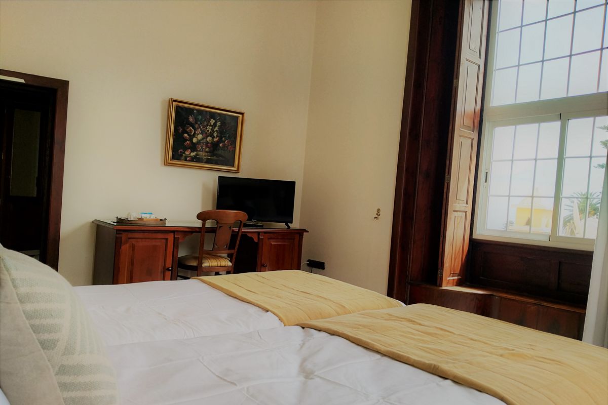Cozy hotel room in Puerto de la Cruz, Tenerife, with a bed, desk, and TV.