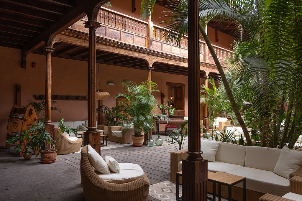 Colonial courtyard in Tenerife with wooden columns and lush greenery.