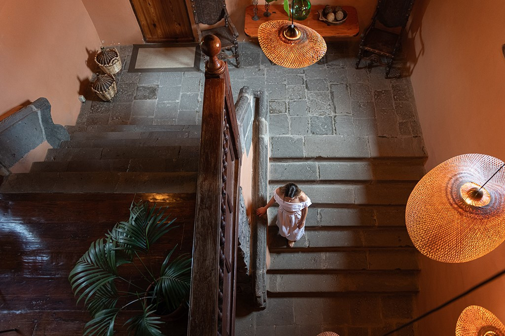 Woman descending a staircase in a warmly lit interior in Tenerife home.