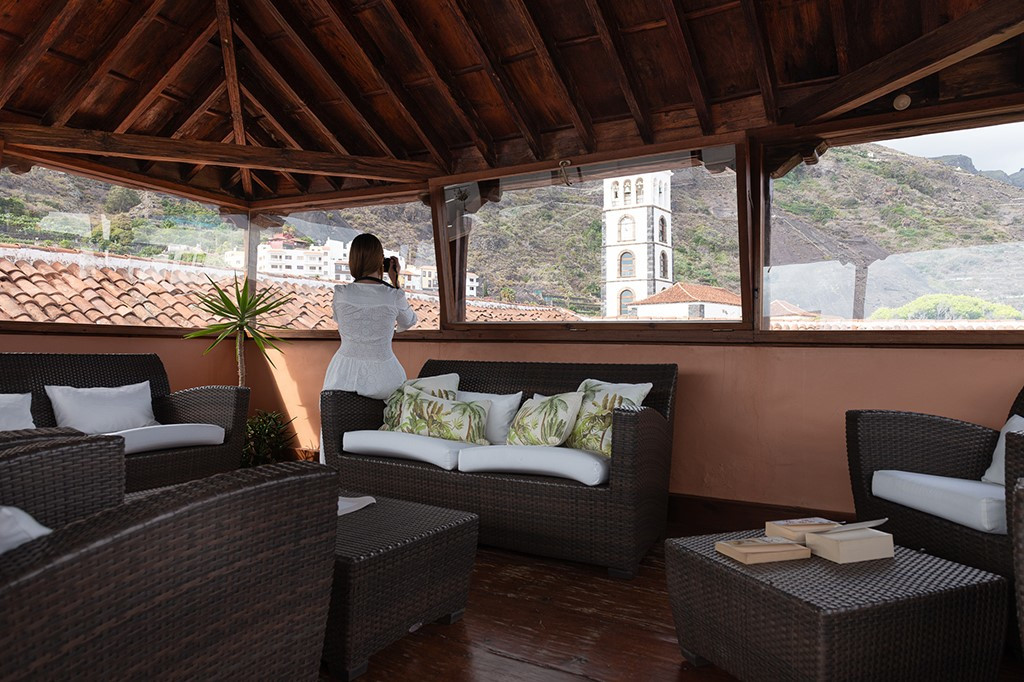 Woman taking photo of church tower from terrace in Tenerife.