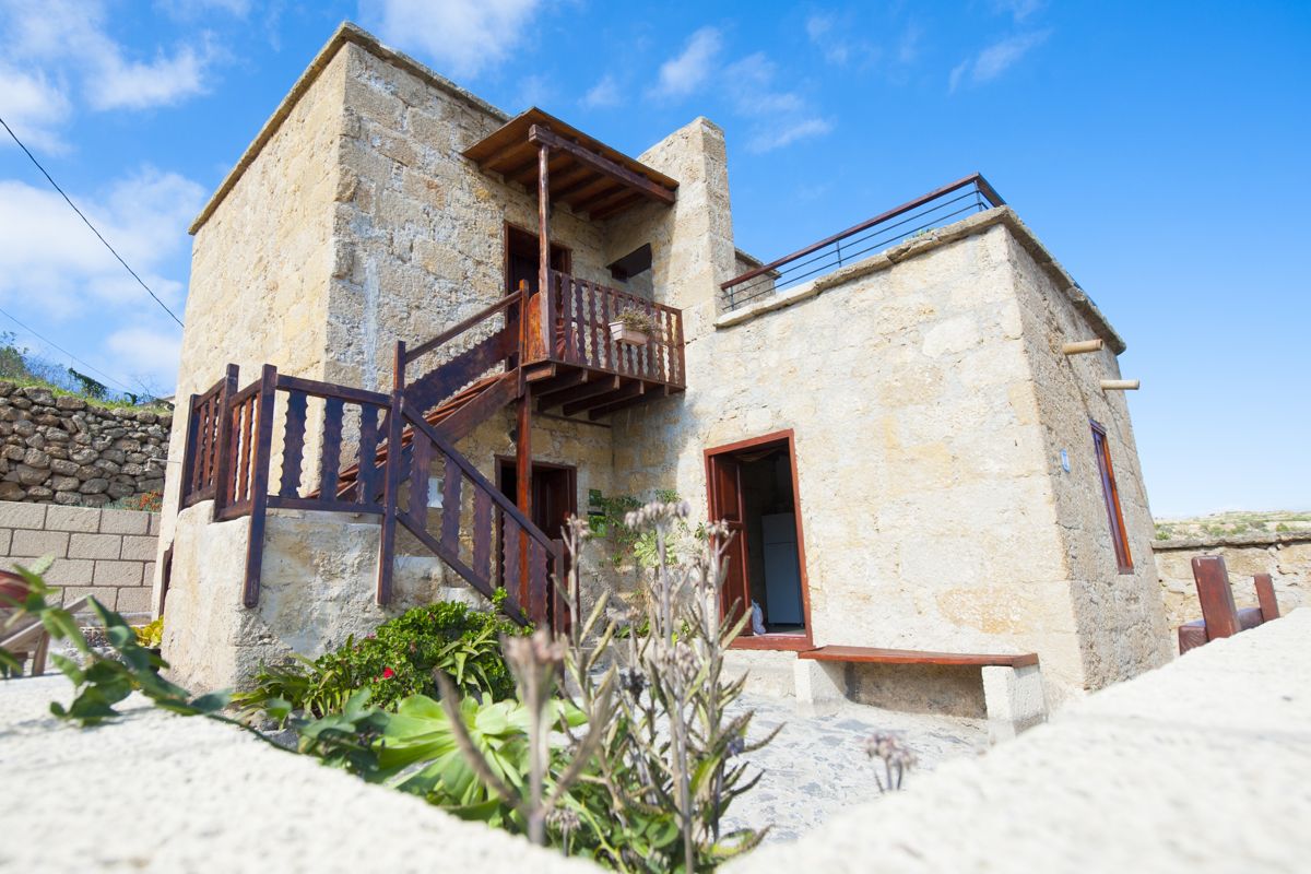 Stone house with wooden stairs and plants in Vallehermoso, Tenerife.