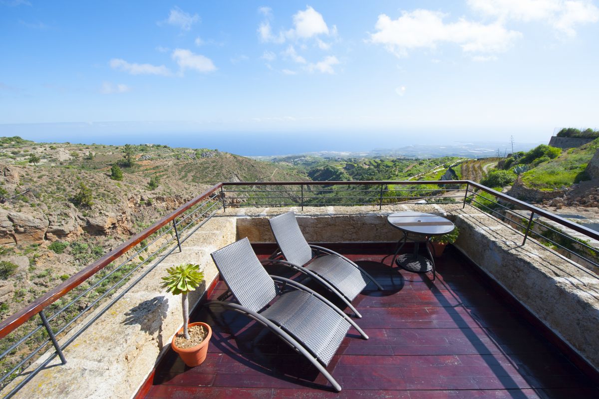 Terrace with two lounge chairs overlooking the sea and mountains in Tenerife.