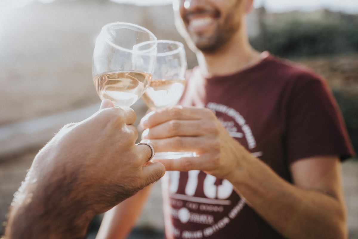 Hands clinking wine glasses while smiling in Tenerife.