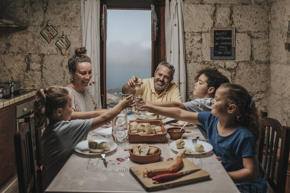 Family toasting in a cozy kitchen in Las Vegas, Tenerife, with a scenic view.