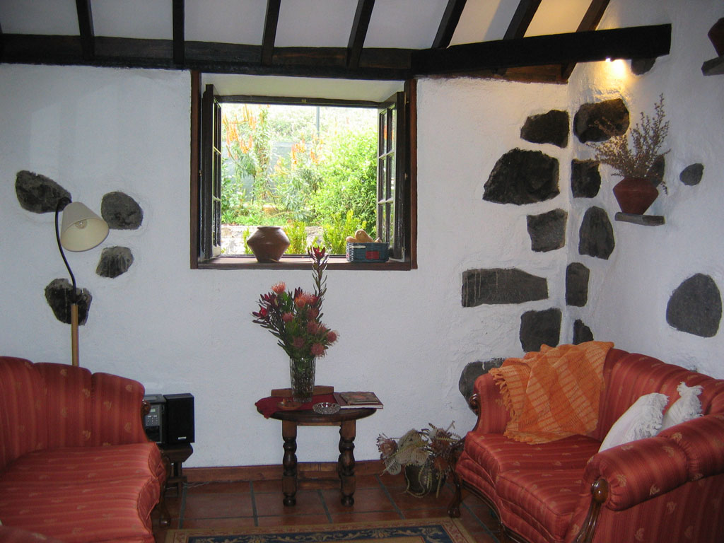 Cozy living room with red sofas, window view of nature in Tenerife.
