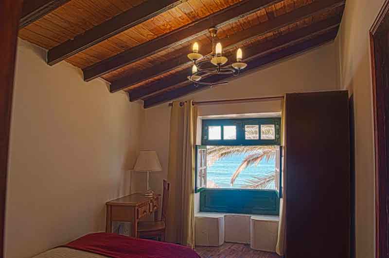 Room with wooden ceiling, chandelier, window view of the sea in Tenerife.