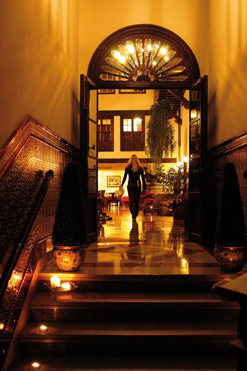 A woman walks through a dimly lit hallway into a restaurant in Tenerife.