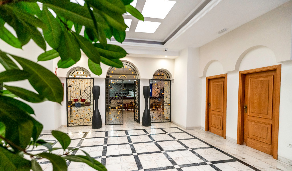 Interior with metal gates and wooden doors in Tenerife building hallway.