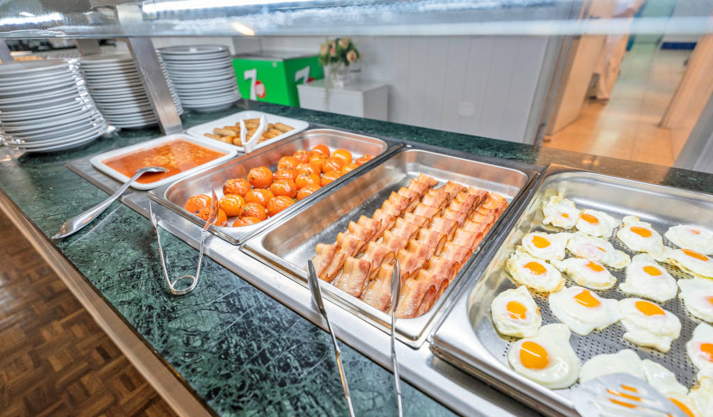 Breakfast buffet with baked beans, sausages, tomatoes, bacon, and fried eggs in Tenerife.